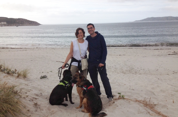 Nuria Villegas dando un paseo por la playa, con otra persona y dos perros